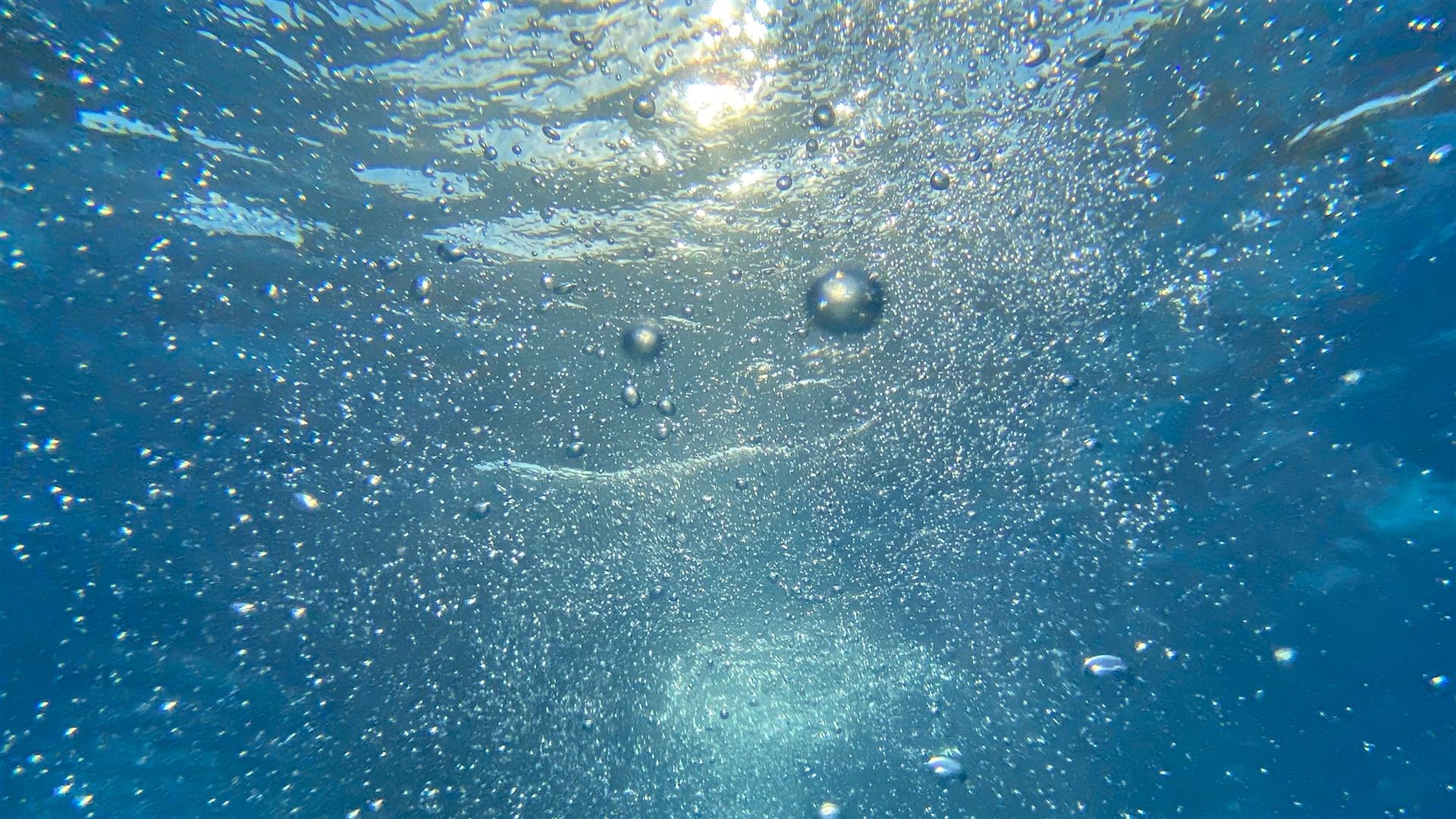 Aufsteigende Luftblasen unter Wasser 